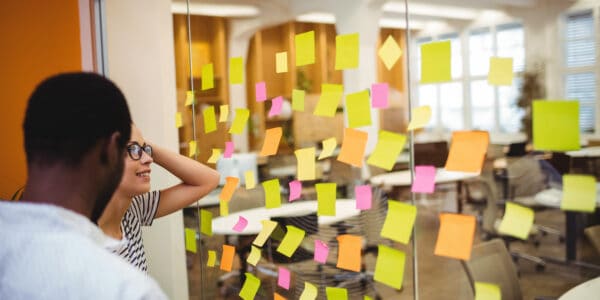 Business executives reading sticky notes in office