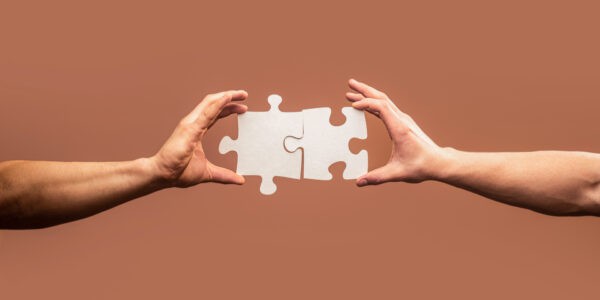 Hand connecting jigsaw puzzle. Business solutions, success and strategy concept. Man hands connecting couple puzzle piece. Business solutions, target, success, goals and strategy concepts.